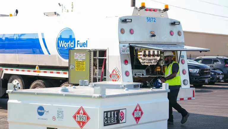 شعار World Fuel Services أمام محطة وقود في إلينوي وميسوري، في سياق خبر استحواذ الشركة على 33 عقداً لموزعين بعلامة تجارية.
