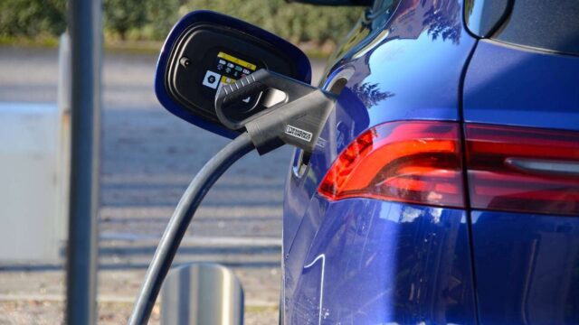 صورة تعبيرية لأسطول مركبات كهربائية يشمل سيارات وشاحنات أمام شعارات EV100 وأسترازينيكا