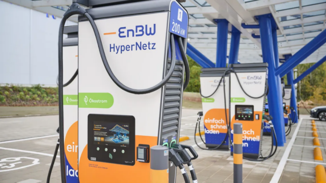 صورة توضح شعار EnBW بجوار محطة شحن مركبات كهربائية في ألمانيا مع رمز ذكاء اصطناعي يبرز المساعدة الرقمية.