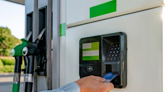 صورة لمحطة وقود توضح عميلًا يستخدم الدفع عند المضخة بجوار مضخات الوقود.